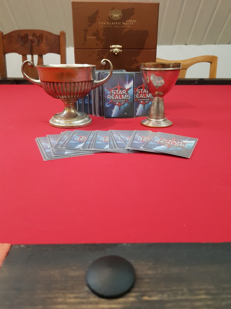 The cups of the competition with star realms cards around them